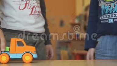 两个男孩在桌旁玩<strong>玩具模型</strong>车